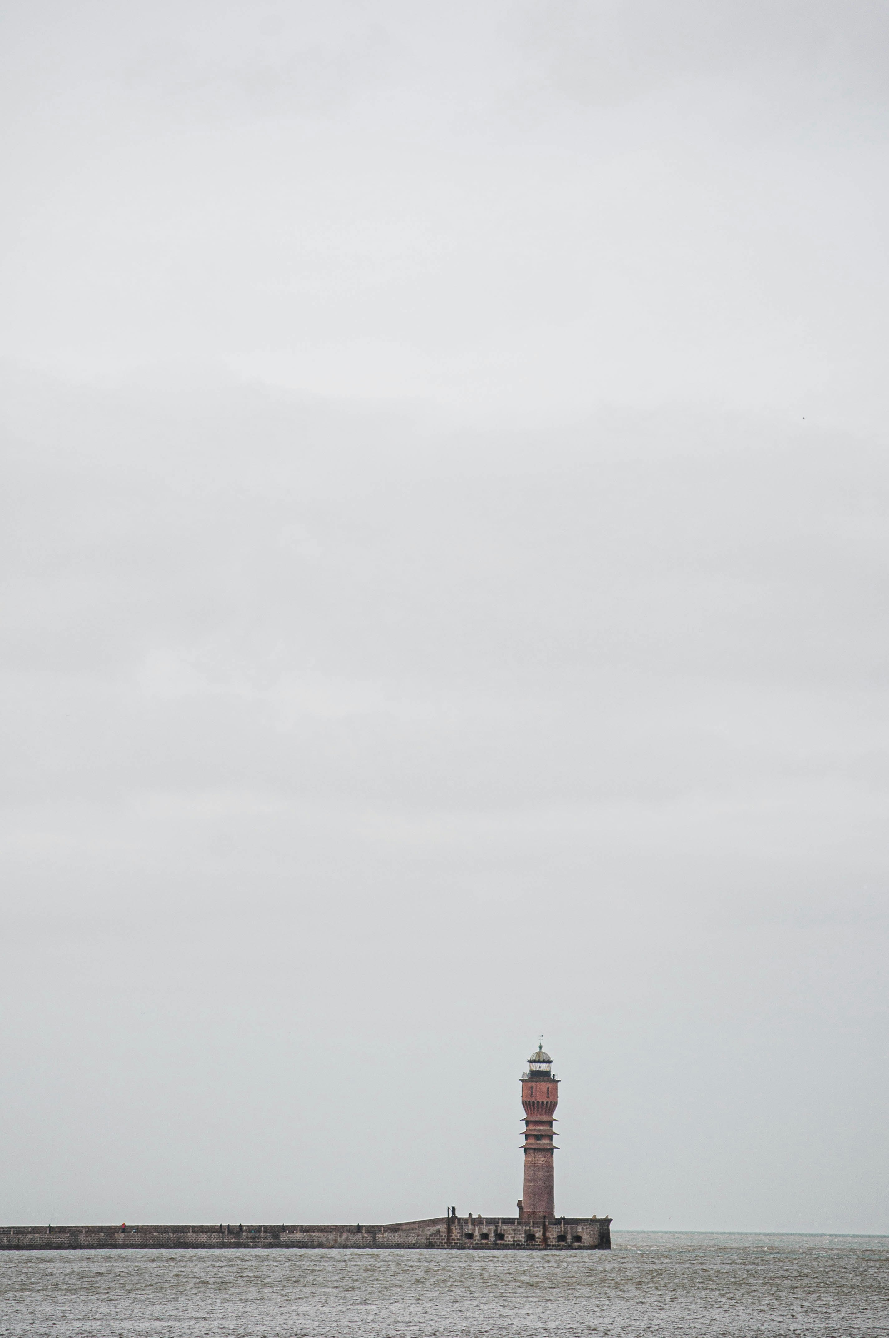 red and white lighthouse under white sky